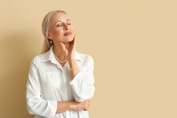 Poster - Mature blonde woman on beige background