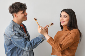 Wall Mural - Young couple with sushi on light background