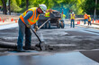 Male worker lays asphalt road repair road paving. A man in overalls is laying asphalt with a shovel, generative ai