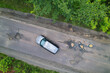 AERIAL TOP DOWN Black car manoeuvres between big and dangerous potholes on road