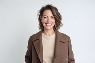 Wall Mural - Medium shot portrait photography of a grinning woman in her 40s that is wearing a versatile overcoat against a white background . Generative AI