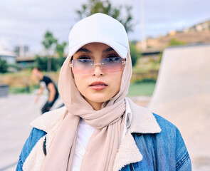 Wall Mural - Portrait, fashion or sunglasses with an arab woman outdoor in a cap and scarf for contemporary style. Islam, faith and hijab with a trendy young muslim female person posing outside in modern eyewear