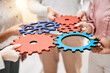 Professional, group and hands with gears for a collaboration in a meeting for support at a company. Teamwork, strategy and corporate employees with a partnership for a common goal for a project.