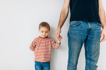 Caucasian little boy, hugging his father at home, isolated image, copy space. Family concept