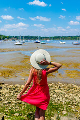 Wall Mural - Woman with hat and red dress,  atlantic ocean and boat- Brittany landscape in France