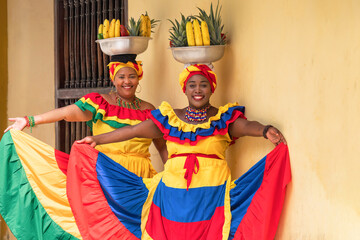 Two cheerful fresh fruit street vendors aka Palenqueras in the Old Town of Cartagena, Colombia. 