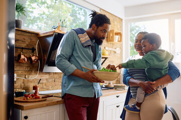 Wall Mural - African American family preparing healthy food in kitchen.