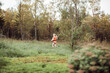 © Flamingo Images - Cute little girl running around a field outside during vacation