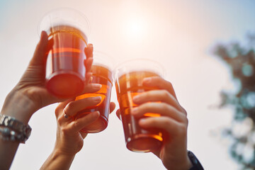 People holding beer cups and enjoying summertime outdoors.