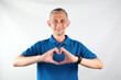 © Tyas Indayanti - Portrait of Asian man wearing blue tshirt smiling with love sign (heart with fingers) on his chest, health concept.
