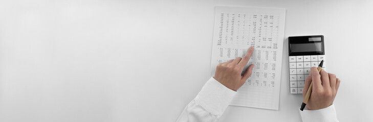 Poster - Accountant using a calculator and points her finger at the numbers in the financial statement.