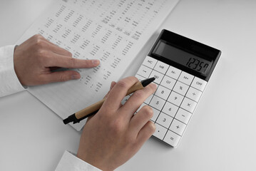 Poster - Accountant using a calculator and points her finger at the numbers in the financial statement.
