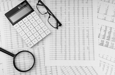 Poster - Calculator, magnifying glass and eye glasses on financial statement. Top view.