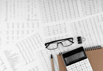 Poster - Calculator, pen,notebook and eye glasses lying on financial statement.