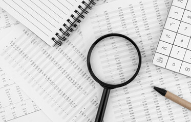Poster - Calculator, magnifying glass, pen lying and notebook on financial statement. Financial concept. Top view.