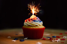 Generative Ai Of Cupcake With Burning Bengal Light Placed On Wooden Table In Dark Room Representing Celebrations Of 4th Of July In United States
