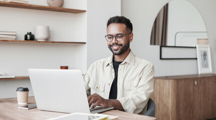 Young man using laptop at home. Businessman or student working on computer online. Freelance, online video conference call, education and technology concept