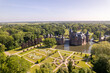 Bright view from above aerial showing historic picturesque castle Ter Haar in Utrecht with typical towers and fairy tale cants facade exterior surrounded by landscaping gardens in the foreground