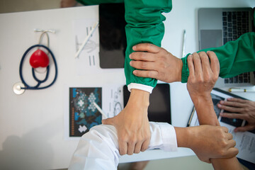 Wall Mural - The medical team joins hands after the meeting and discusses the treatment of severely ill patients and can come to a conclusion on the surgical treatment of the patient. Medical team meeting concept