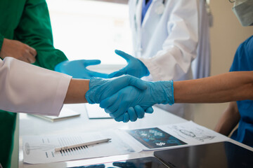 Wall Mural - The medical team joins hands after the meeting and discusses the treatment of severely ill patients and can come to a conclusion on the surgical treatment of the patient. Medical team meeting concept