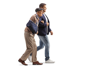 Wall Mural - Young man walking with a senior man with an injured arm in a sling