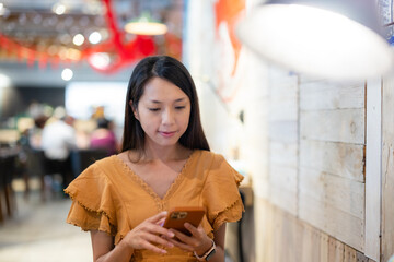 Wall Mural - Woman use of mobile phone inside coffee shop