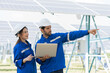Male and female engineer worker working in solar panels power farm. Two technician working at solar power station