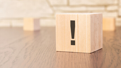 Poster - wooden blocks with exclamation point on wooden table, close up. space for text