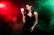 Studio photo luxury gorgeous woman dealer posing in neon fog filter hold card vip private party poker club poker night