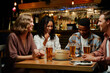 © StratfordProductions - Happy young multiracial group of friends in casual clothing laughing over dinner at restaurant