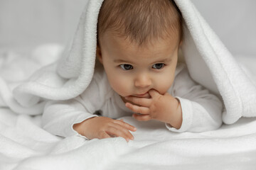 Wall Mural - Little infant baby lying on white soft blanket at natural light, candid portrait of newborn child