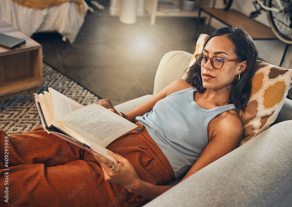 Woman relax on sofa, reading book at house and break on the weekend with literature, fantasy