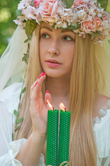 Bride making magic of candles, magical attributes, herbs and flowers, Slavic Wicca rituals and esoteric concept