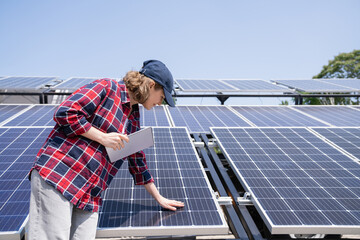 Woman with digital tablet touching solar panel