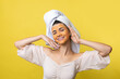 © Budjak Studio - A pretty young girl with a scrub mask on her face poses for the camera and smiles against a yellow background.