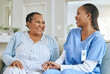 © Siphosethu F/peopleimages.com - Senior woman, nurse and laughing together for support, healthcare and happiness at retirement home. Black person or patient and caregiver holding hands for trust, elderly care and help for wellness