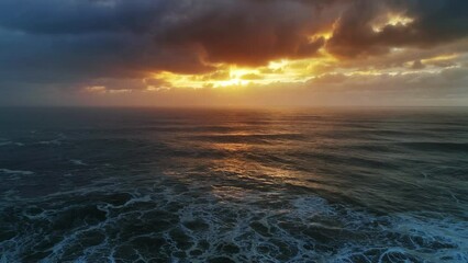 Wall Mural - aerial view on big waves of atlantic ocean and dramatic sunset sky, 4k