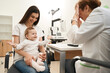 © Svitlana - Baby sitting on mother lap in ophthalmologist office