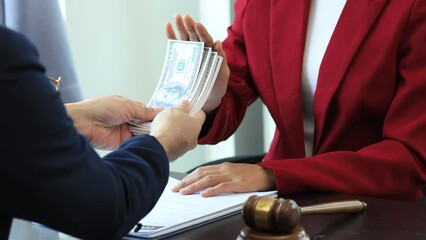 Wall Mural - Business man raised her hand to deny accepting a bribe from a business partner, a brown envelope containing a large number of dollar bills as money for bribery, a corruption concept.