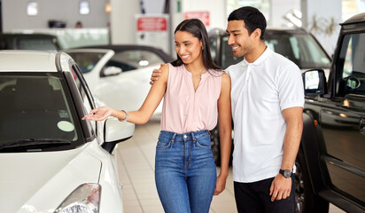 Canvas Print - Couple at car dealership, choice and transport with smile, people buying new vehicle with luxury and customer. Happy with decision, man and woman at automobile showroom, purchase and transportation