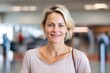 © Robert MEYNER - Portrait of happy mature woman smiling at camera in corridor of shopping mall
