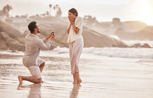 Couple At Beach, Surprise Proposal And Engagement With Love And Commitment With Ocean And People Outdoor. Travel, Seaside And Man Propose Marriage To Woman, Wow Reaction And Happiness With Care