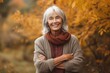Medium shot portrait photography of a pleased woman in her 60s that is wearing a cozy sweater against a brilliant display of fall foliage in a forest background . Generative AI