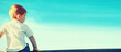 © guas - Little child boy sitting and pensive looking away outdoors on sunset on blue sky background, view from back