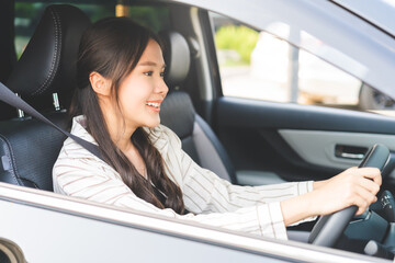 Transport concept, happy smile brunette hair asian young woman driving, getting new car, vehicle for travel, trip with face positive, female driver car with fasten safety seat belt before traveling.
