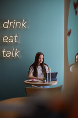 Aufkleber - Beautiful young woman sitting in a cafe with tablet computer, eating desserts and drawing a sketch. Freelance graphic designer working in a restaurant