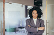 © Liubomir - Portrait of serious female boss inside business company office, businesswoman crossed arms looking concentrated at camera, wearing shirt, satisfied and successful woman with curly hair.