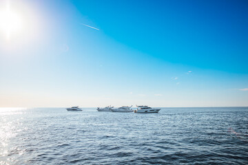 Luxury yachts docked in sea at sunset. Modern motor boats and blue water. Yacht sailing on a sunny day