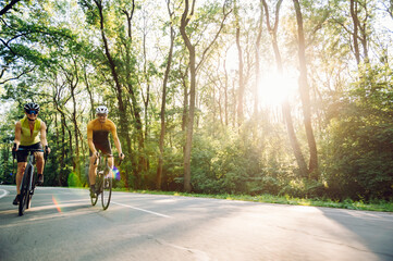 Wall Mural - Couple riding bicycles outside of the city and wearing helmets and sunglasses