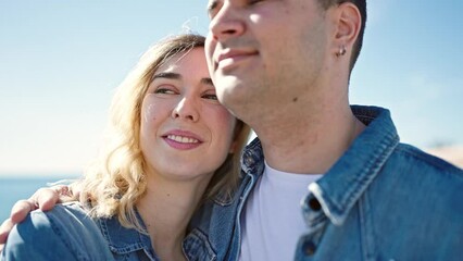 Poster - Man and woman couple smiling confident hugging each other at seaside